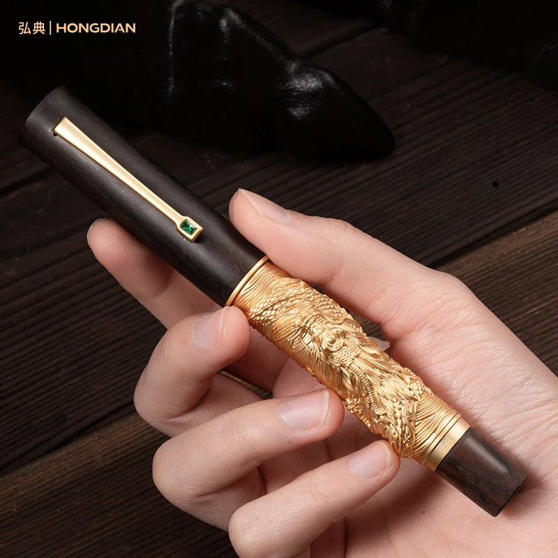 Hand holding a decorative pen with gold and brown design on a wooden surface, brand 'HONGDIAN' visible.