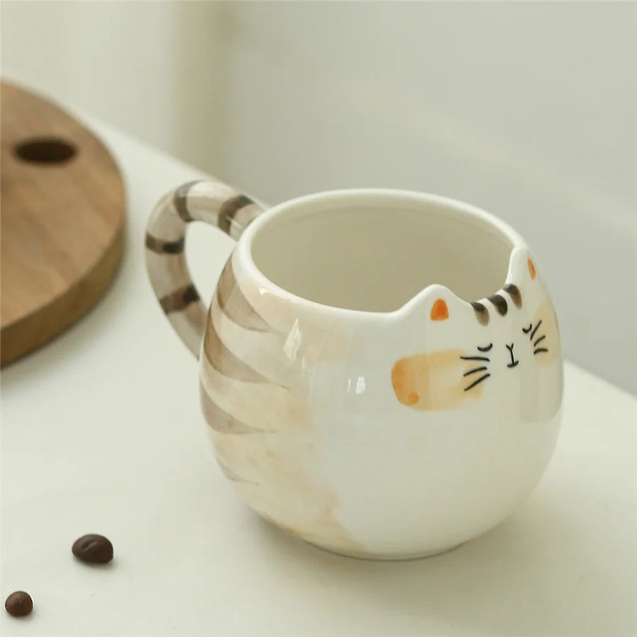 Cat-shaped ceramic mug with a handle on a light surface.