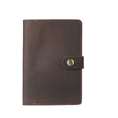 Brown leather notebook with a gold buckle on a white background
