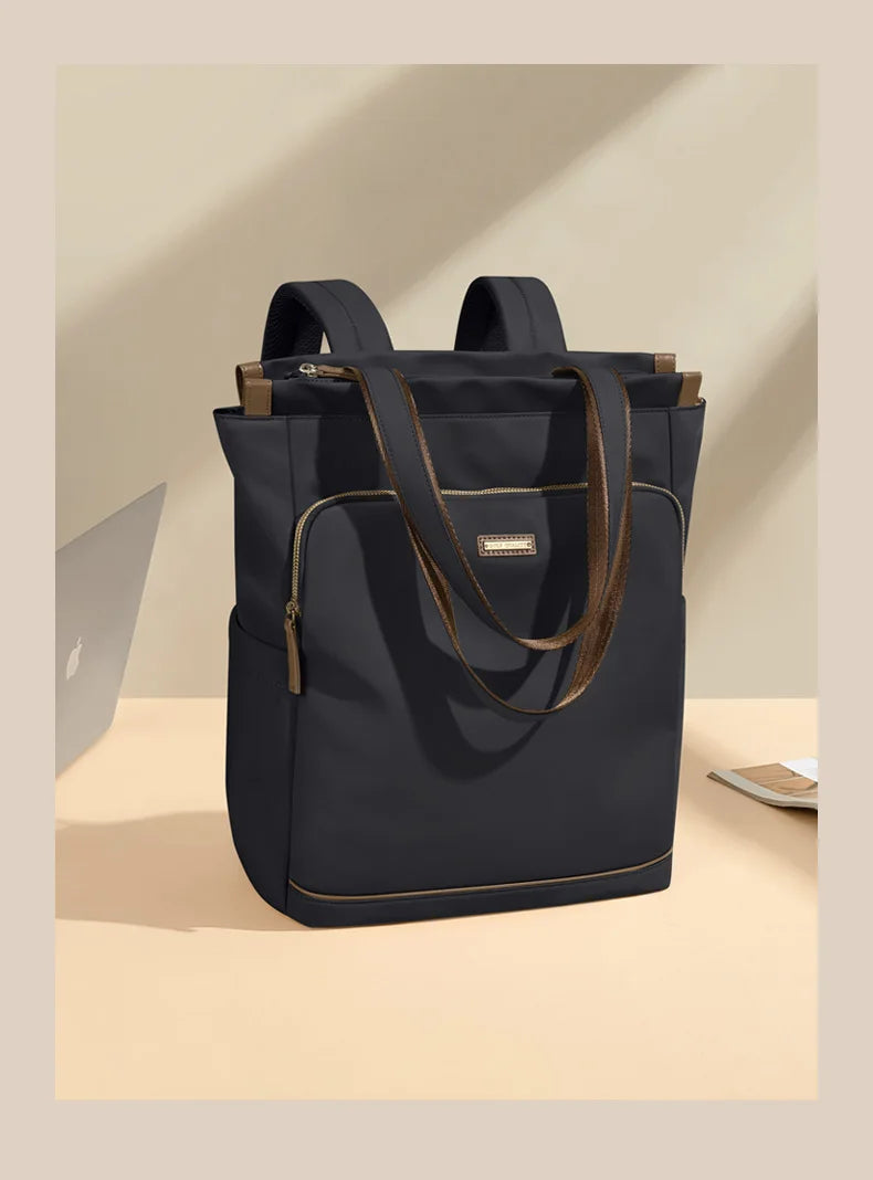 Black tote bag with brown accents on a beige surface