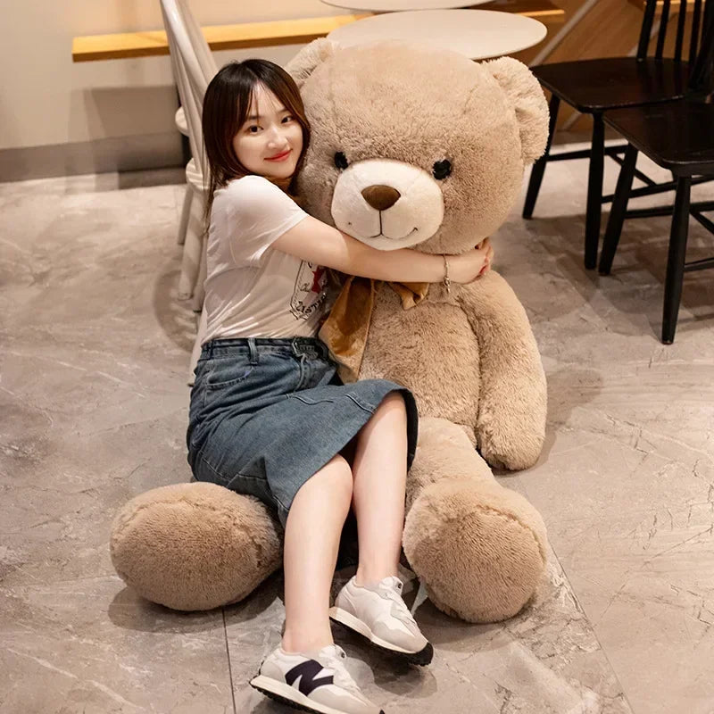 Woman sitting on a large teddy bear in an indoor setting