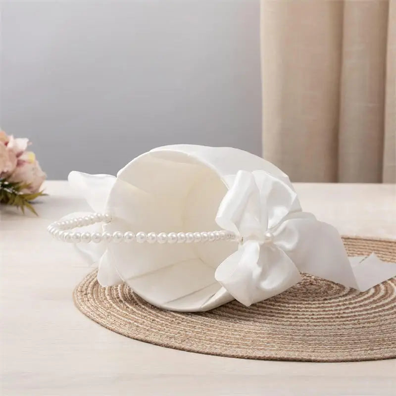 White headscarf with a bow and pearl details on a neutral background