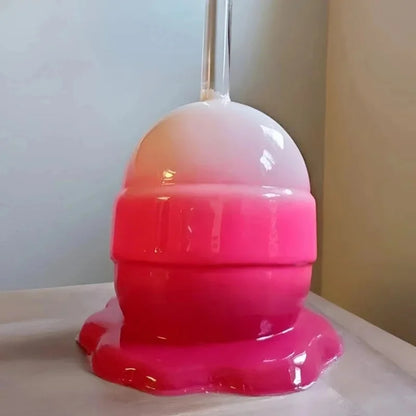 Pink and orange object on a white surface with a neutral background