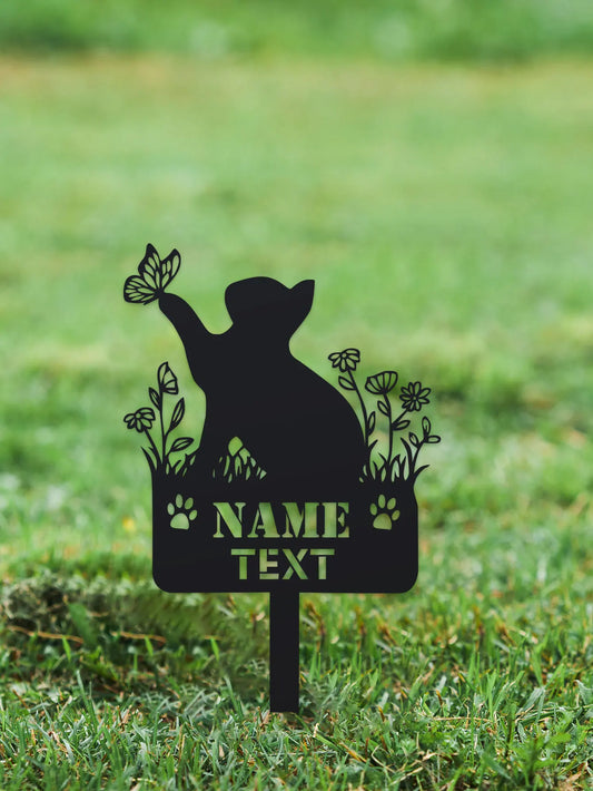 Silhouette of a cat with a butterfly and flowers on a grassy background