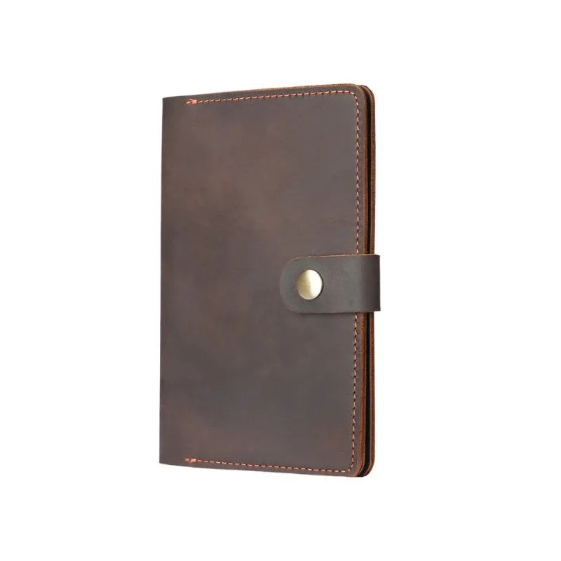 Brown leather notebook with a gold buckle on a white background