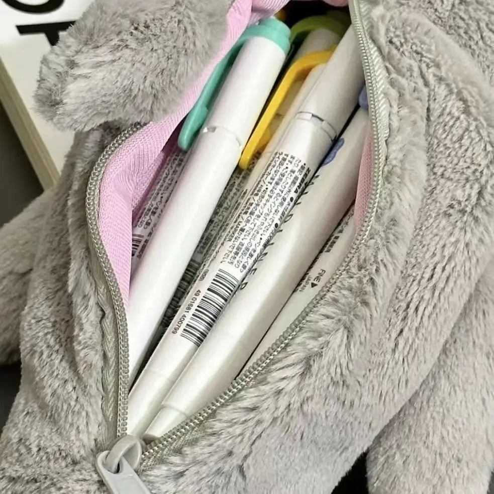 Pens in a gray plush pouch with a pink interior