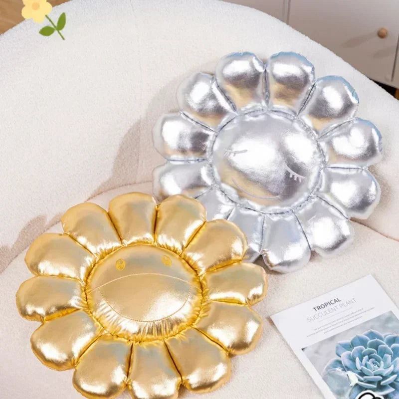 Two metallic sun-shaped coasters, one gold and one silver, on a surface with a magazine in the background.