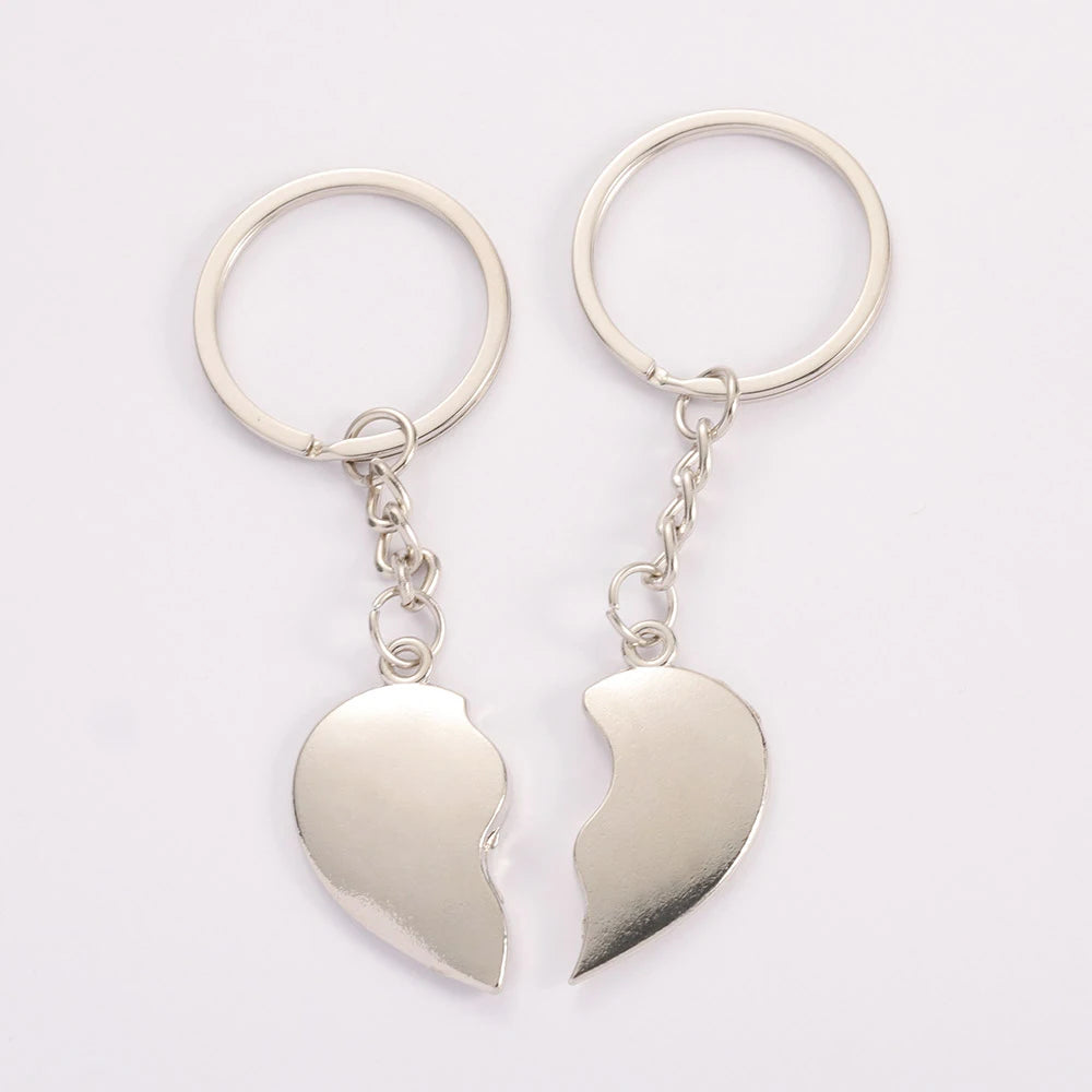 Two silver heart-shaped keychains on a white background