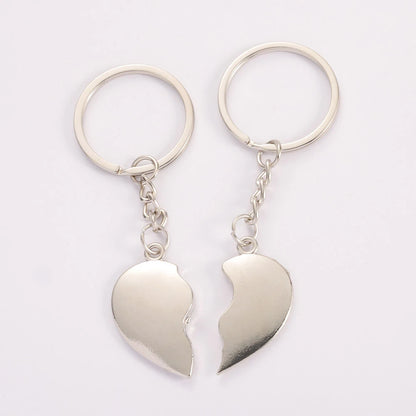 Two silver heart-shaped keychains on a white background