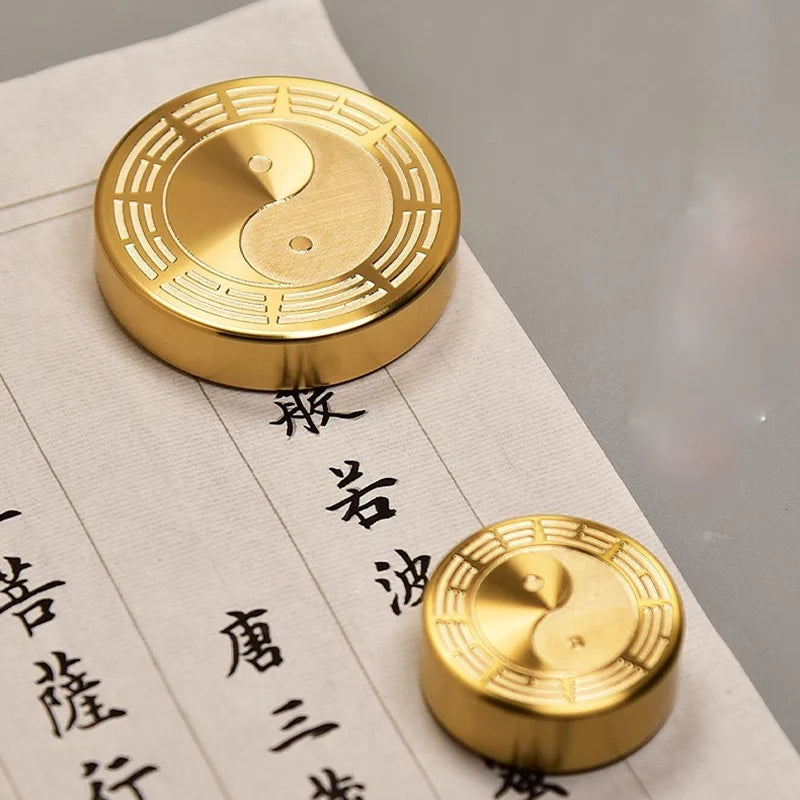 Two gold coins with yin-yang symbol on a piece of paper with Chinese characters.