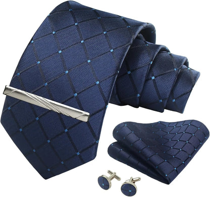 Navy blue patterned tie set with silver tie clip, cufflinks, and pocket square on a white background