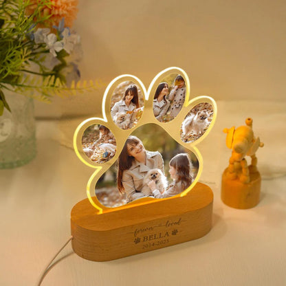 Wooden paw-shaped photo frame with family memories on a table.