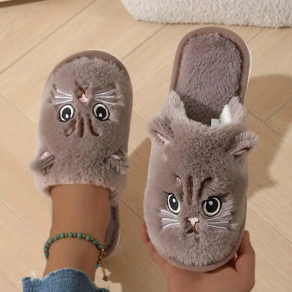 Cat-shaped slippers worn by a person on a wooden floor