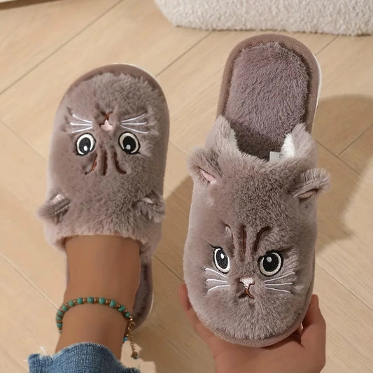Cat-shaped slippers worn by a person on a wooden floor