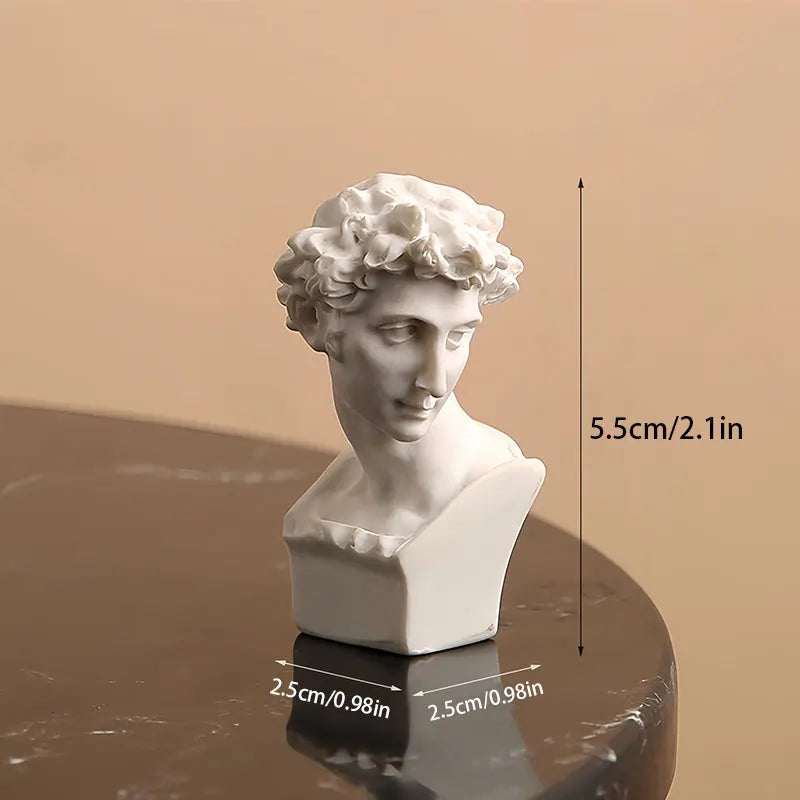 White classical bust sculpture on a reflective surface with measurement markings.