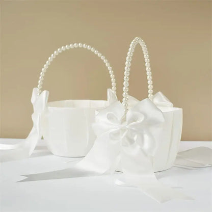 White flower girl basket with pearl handle on a beige background