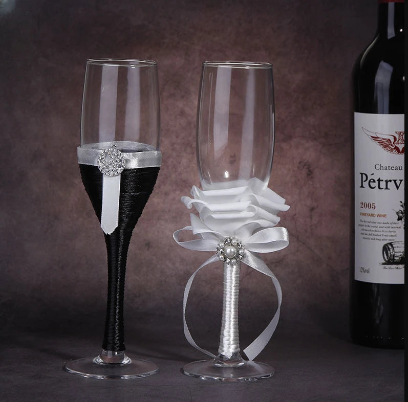 Two decorative champagne flutes with ribbons and a bottle of Chateau Petrus in the background.