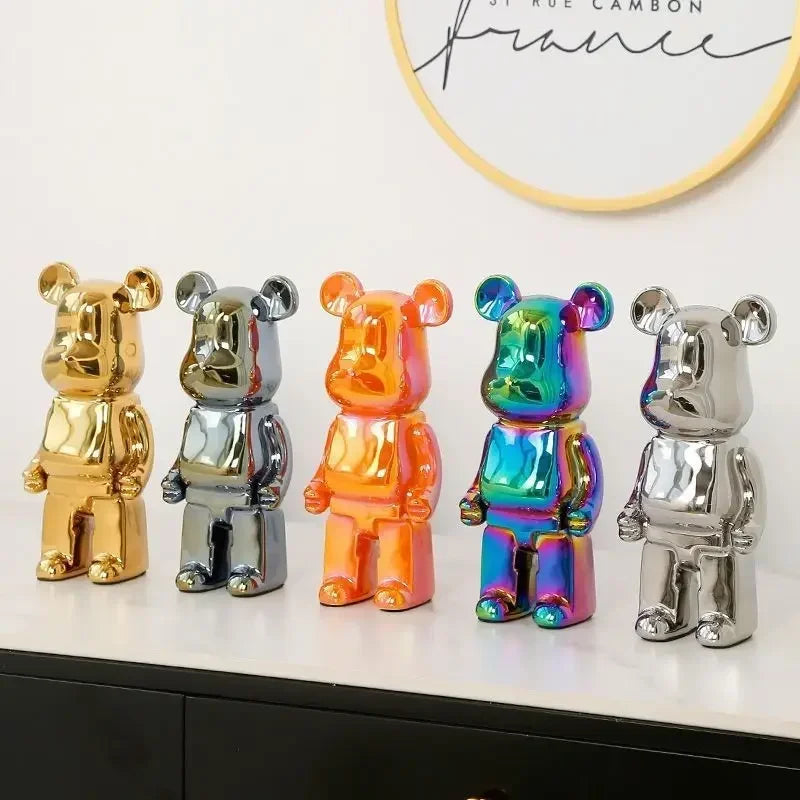 Five colorful bear-shaped decorative items on a white surface with a blurred background.