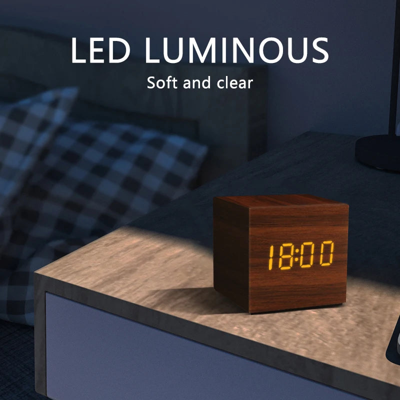 Wooden digital clock on a nightstand with 'LED LUMINOUS' text above it.