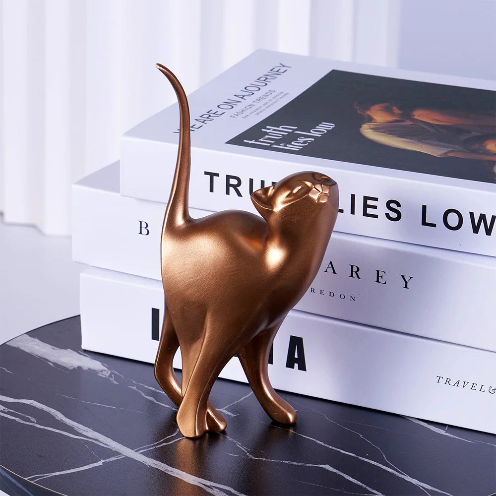 Bronze cat figurine on a stack of books with a blurred background