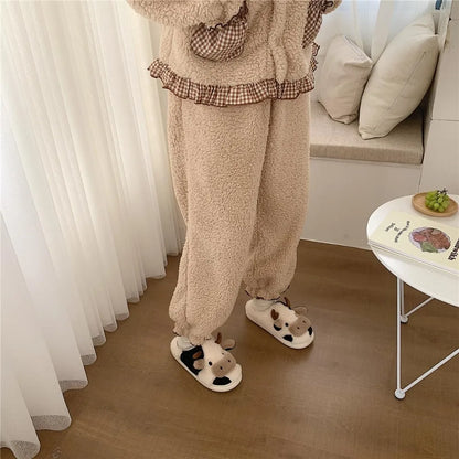 Person wearing a cozy outfit with fluffy pants and slippers in a home setting.