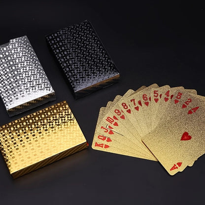 Gold and silver playing card boxes with gold playing cards on a black background