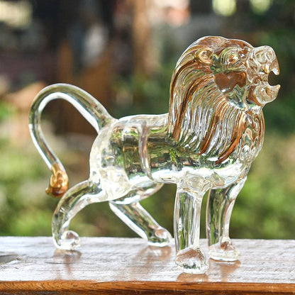 Clear glass lion statue on a wooden surface with a blurred natural background
