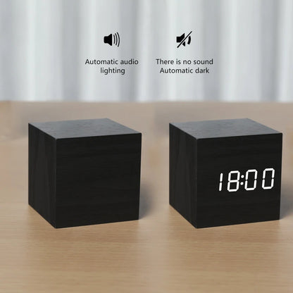 Two black square devices on a wooden surface with digital clock display and text indicating features.