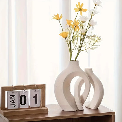 Decorative vases with flowers on a wooden surface