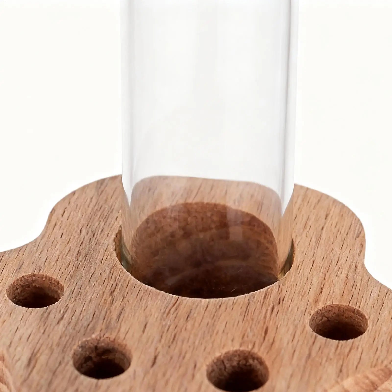 Wooden stand with a clear cylindrical glass on a white background