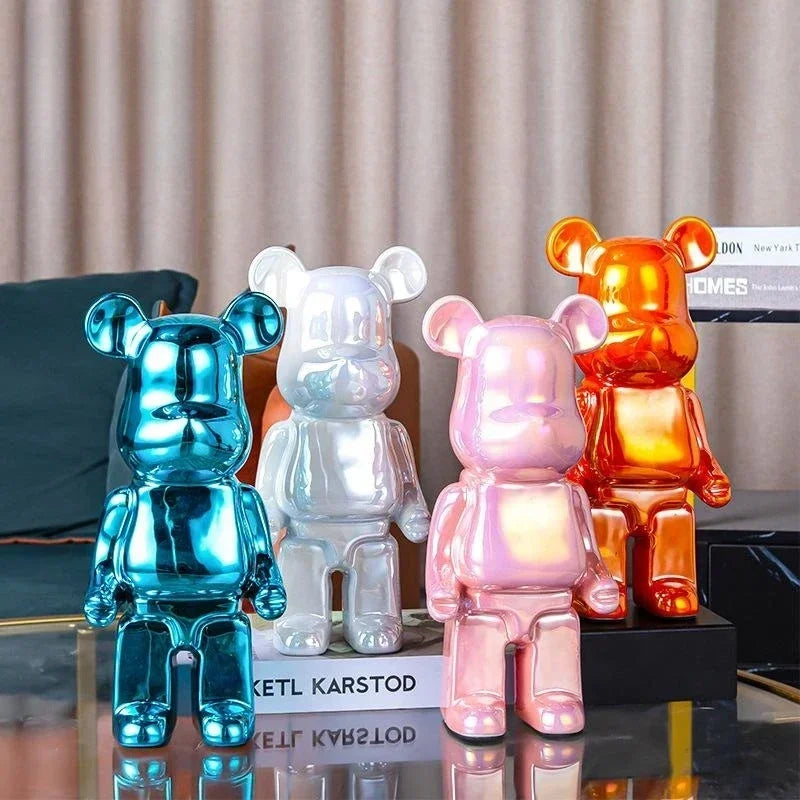 Four colorful bear-shaped lamps on a reflective surface with a neutral curtain background