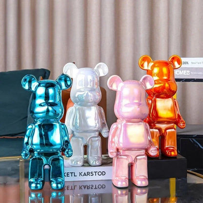 Four colorful bear-shaped lamps on a reflective surface with a neutral curtain background