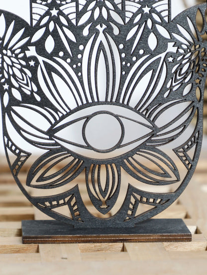 Decorative wall art with a central eye design on a wooden stand.