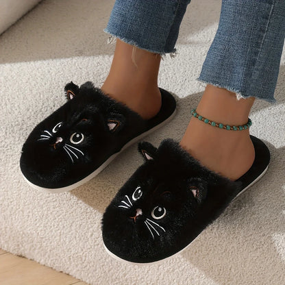 Black cat slippers worn with denim jeans on a light carpet.