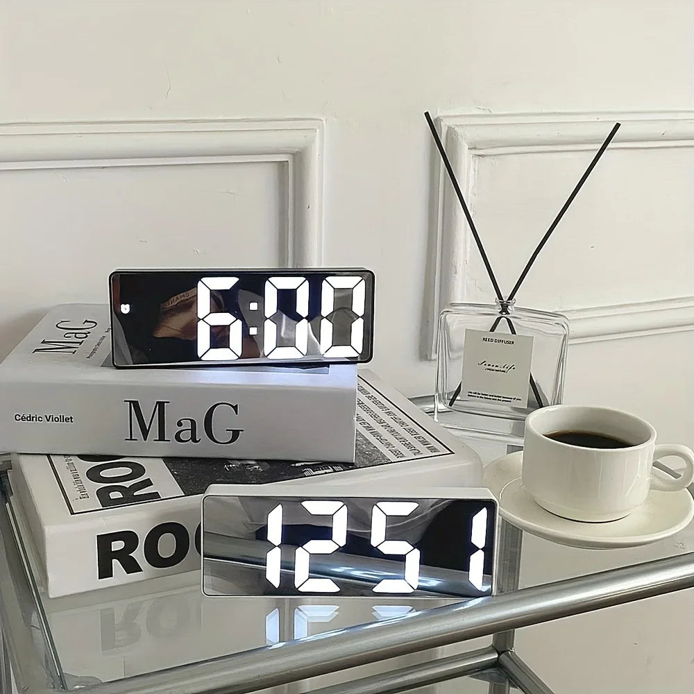 Digital clock on a table with books and a cup of coffee