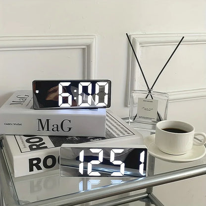 Digital clock on a table with books and a cup of coffee
