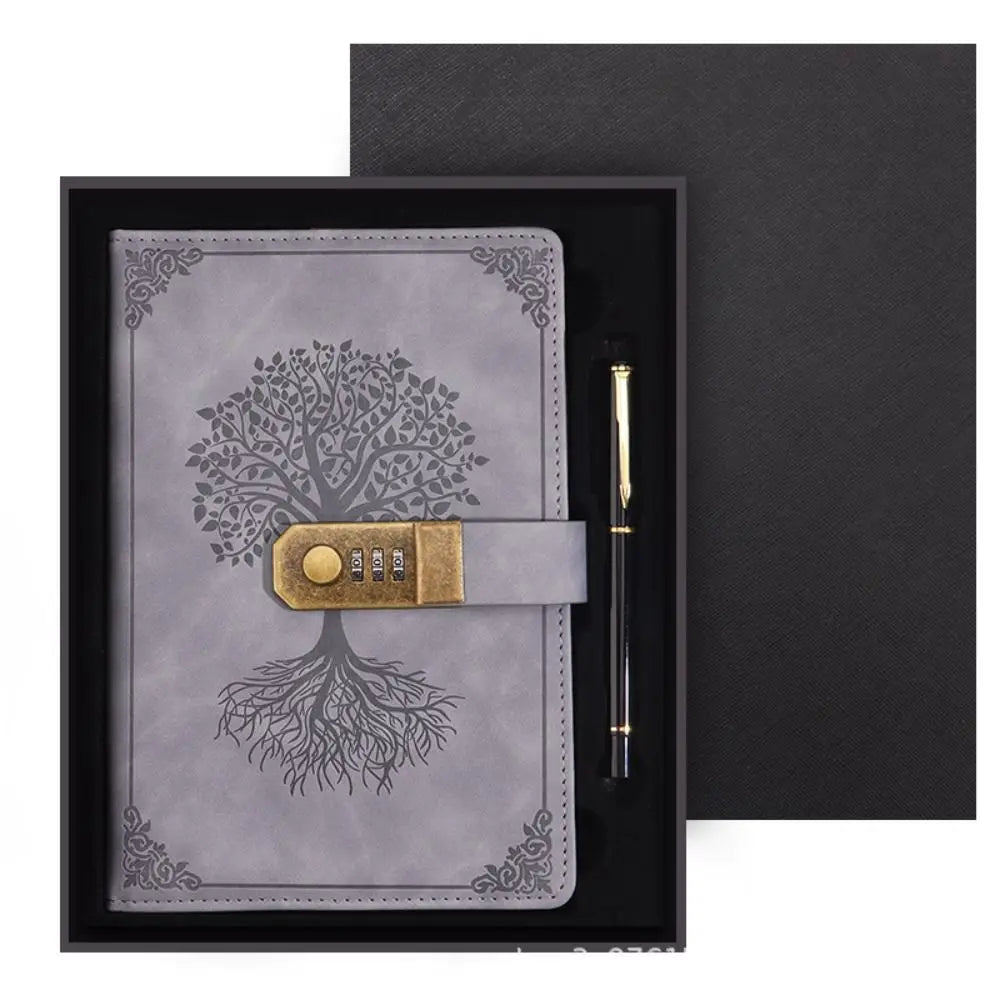 Gray leather notebook with tree design and combination lock, accompanied by a pen, in a black box.