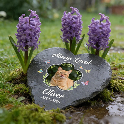 Memorial stone with a cat's photo and 'Always Loved Oliver' text, surrounded by purple flowers.