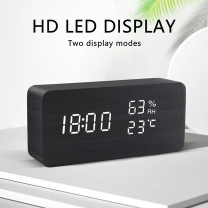 Digital clock with LED display showing time, temperature, and humidity on a white surface.