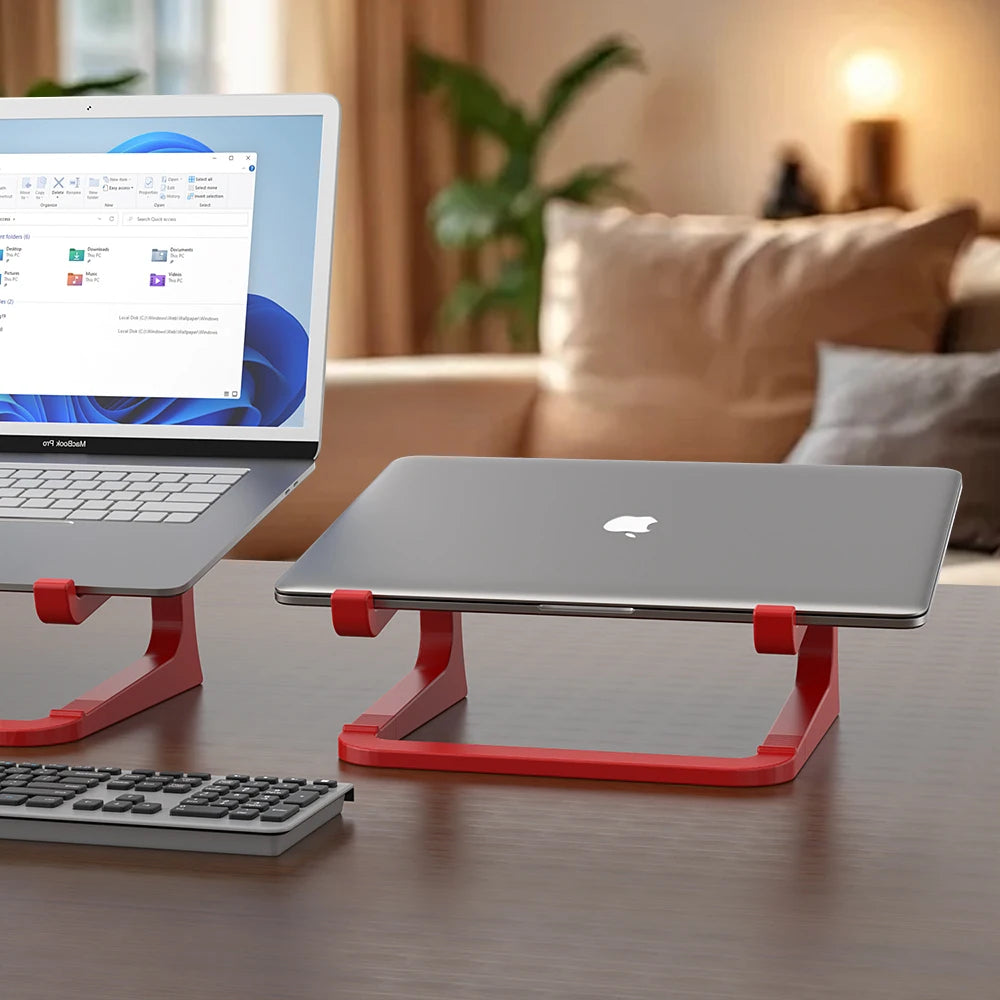 Two laptops on red stands with a blurred living room background