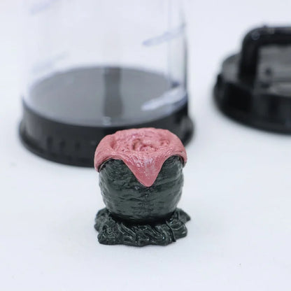 Decorative object with pink top and black base on a white background
