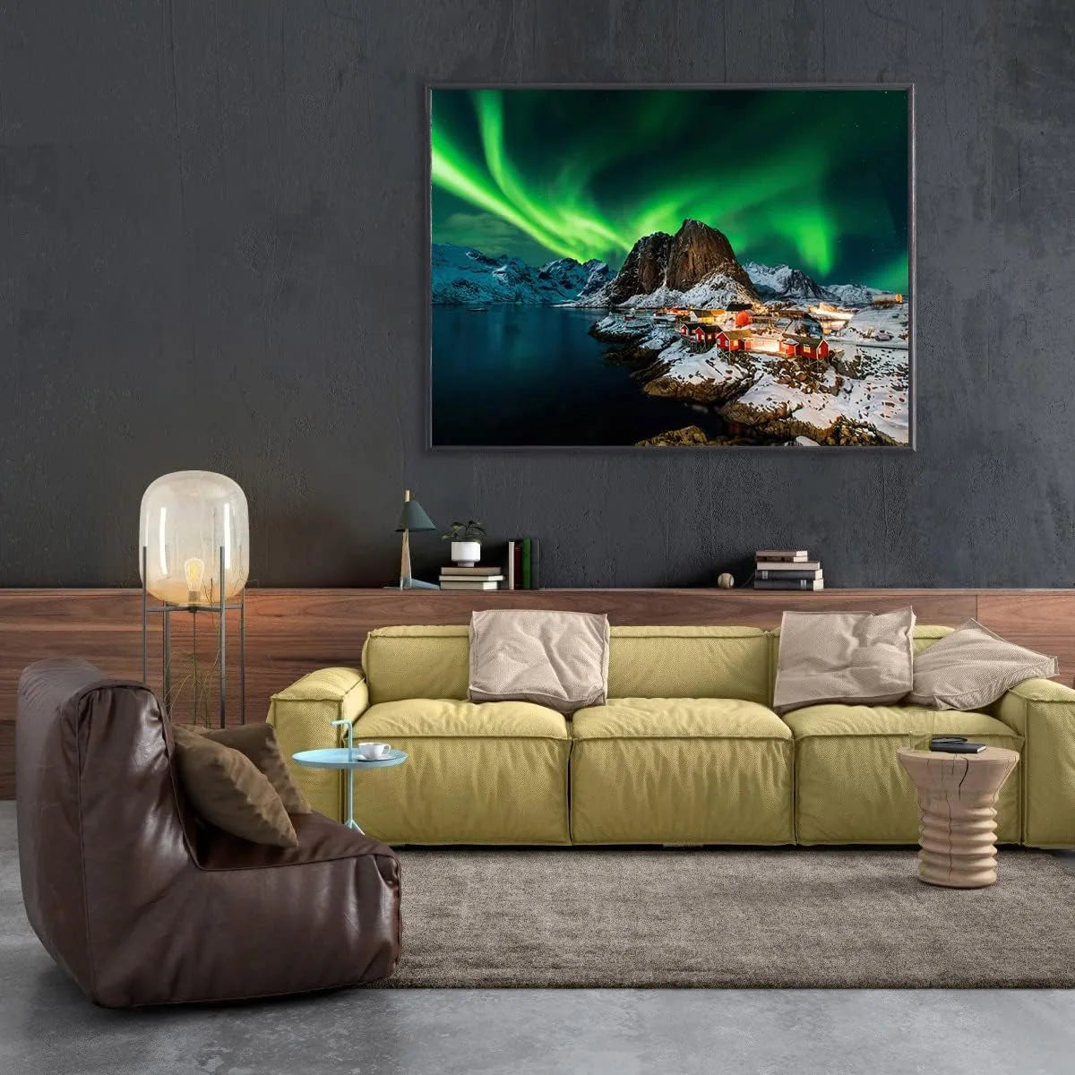 Living room with a green sofa, brown armchair, and a large wall-mounted TV displaying a scenic image.