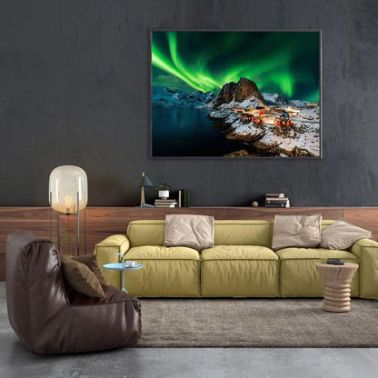 Living room with a green sofa, brown armchair, and a large wall-mounted TV displaying a scenic image.