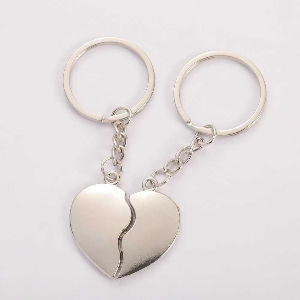 Two silver heart-shaped keychains with a split design on a white background