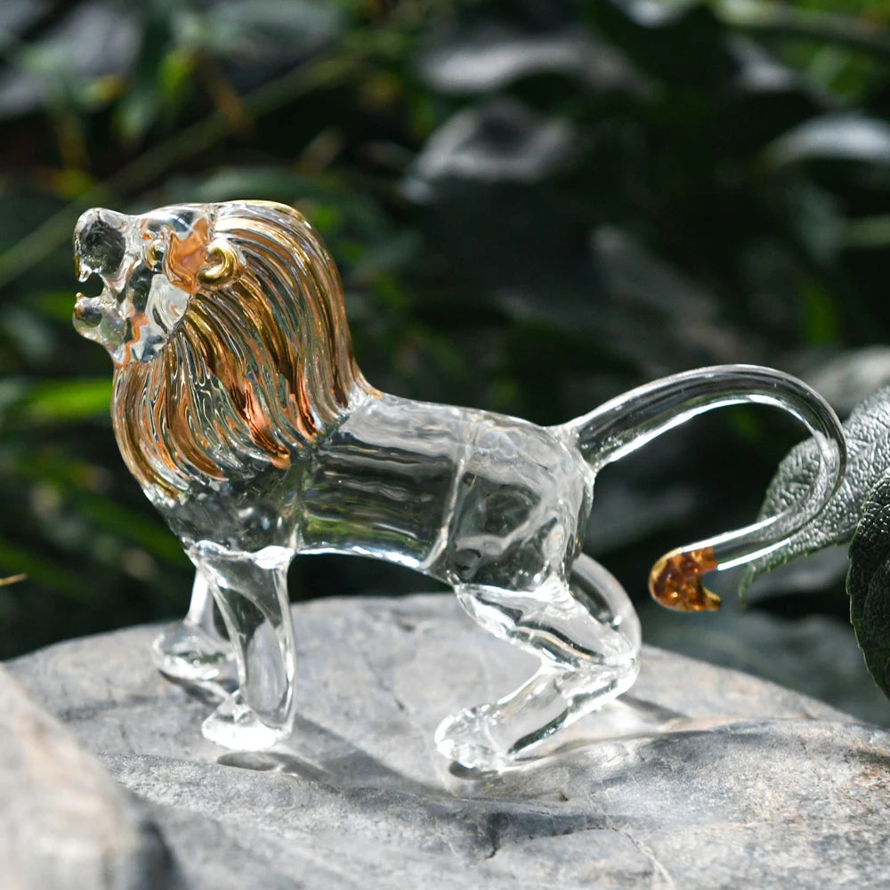 Clear glass lion figurine on a stone surface with a blurred natural background