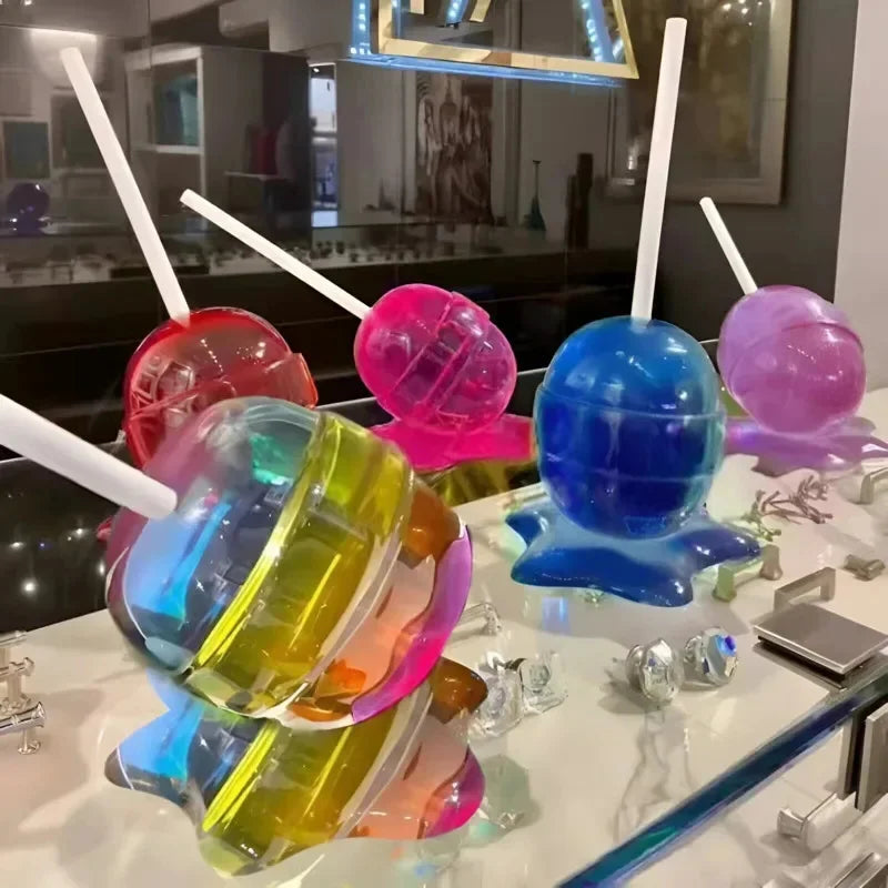 Colorful gelatin dessert with straws on a white surface.