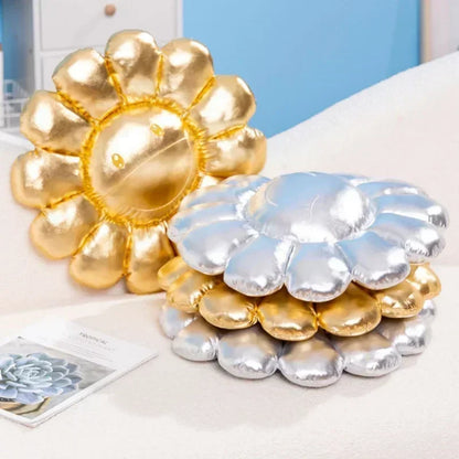 Gold and silver flower-shaped inflatable pillows on a white surface.