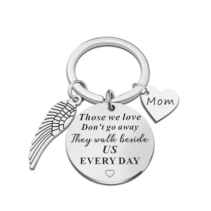 Keychain with angel wing, heart-shaped 'Mom' tag, and engraved message on a white background
