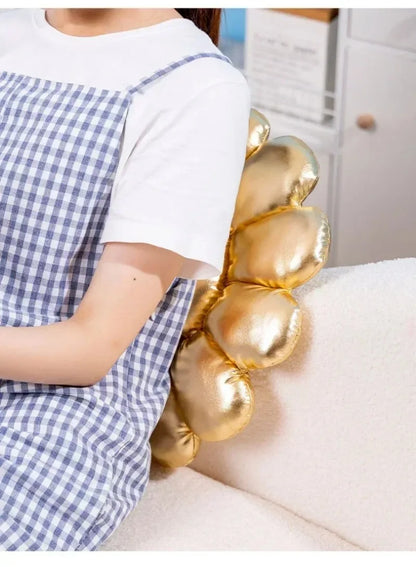 Person wearing a large gold bracelet with a checkered dress and white shirt.