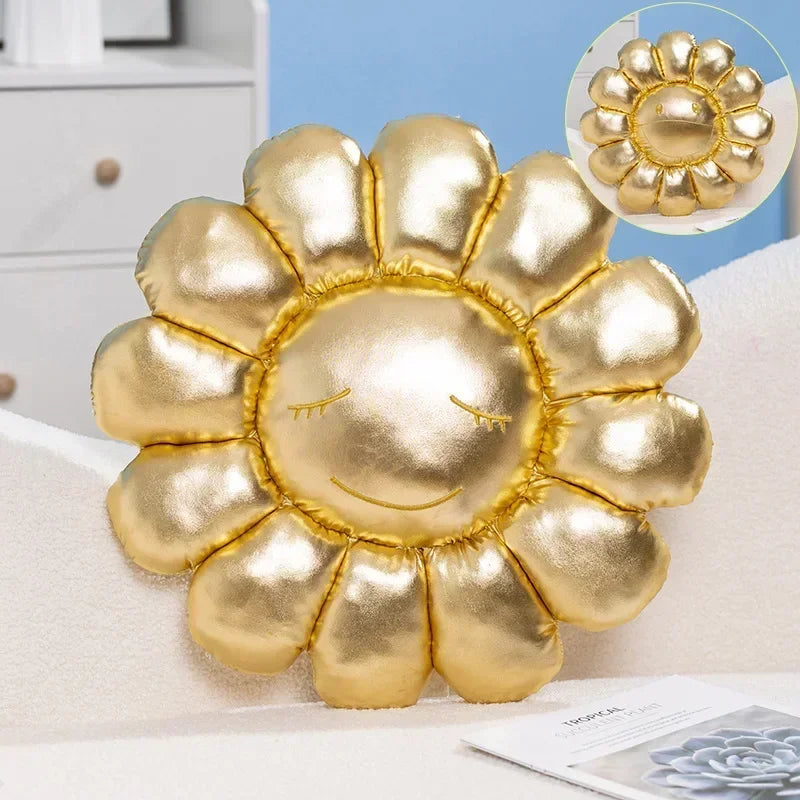 Gold sun-shaped pillow with a face on a white surface